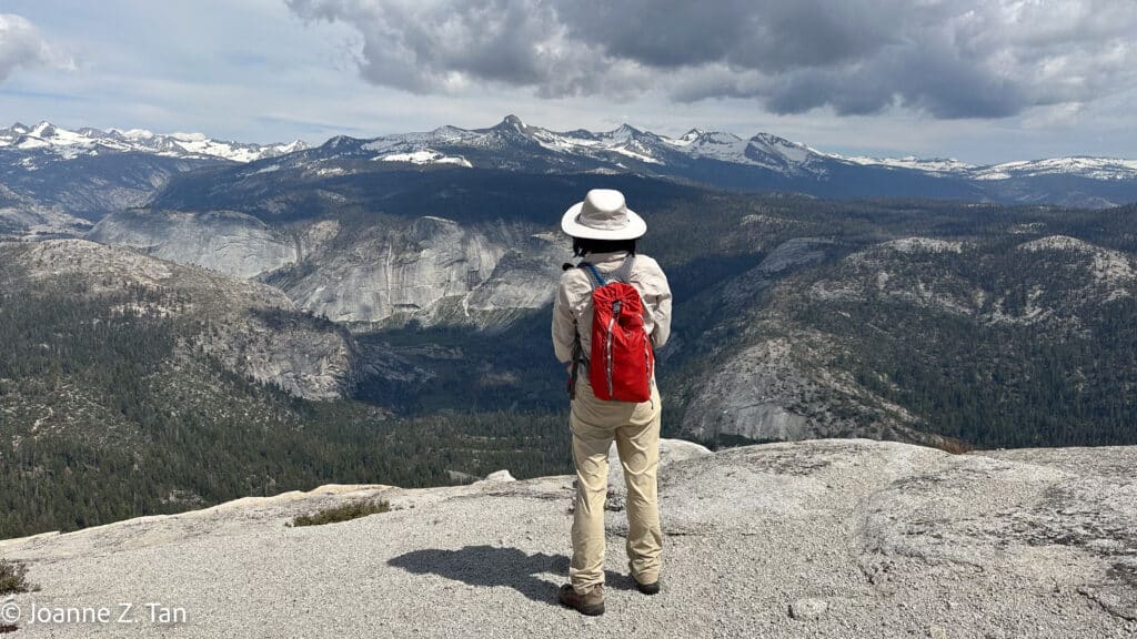 On top of Half Dome looking at the snow capped mountains, Joanne Z. Tan, writer, award-winning photographer & poet, global top brand strategist, branding expert.