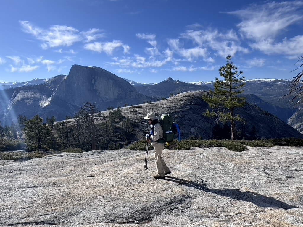 Joanne Z. Tan carries a backpack on North Dome across Half Dome, in her backpacking story in Yosemite wilderness as poet, writer, photographer, brand strategist.