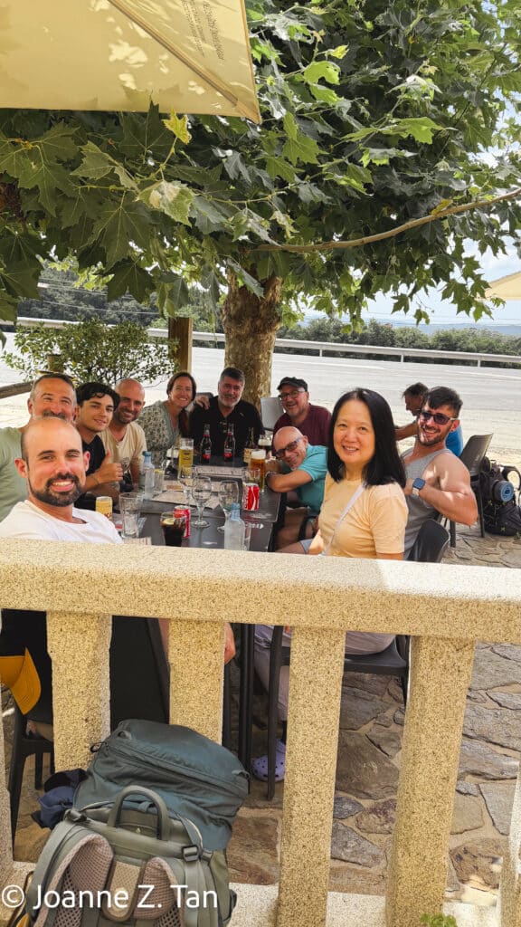 Joanne Z. Tan and Spaniards pilgrims are eating together on Camino de Santiago Primitivo in Aug 2026, as part of her 3-week adventure in Spain.